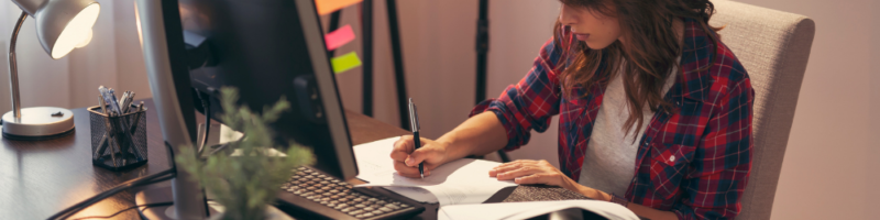 person sitting at a desk - writing. 